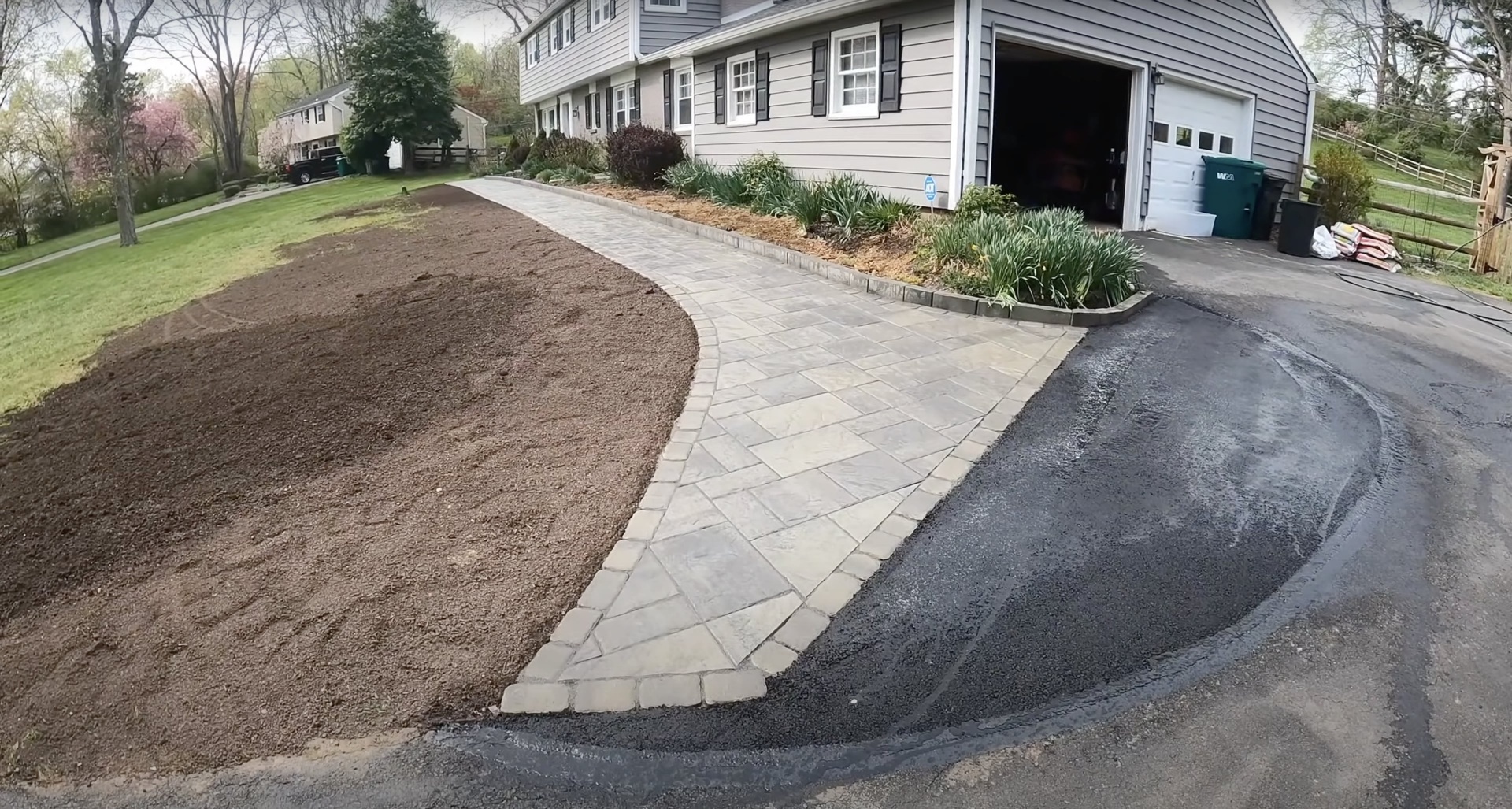Custom curved stamped concrete driveway with decorative stone pattern Curved stamped concrete driveway and walkway with decorative pattern and professional landscaping