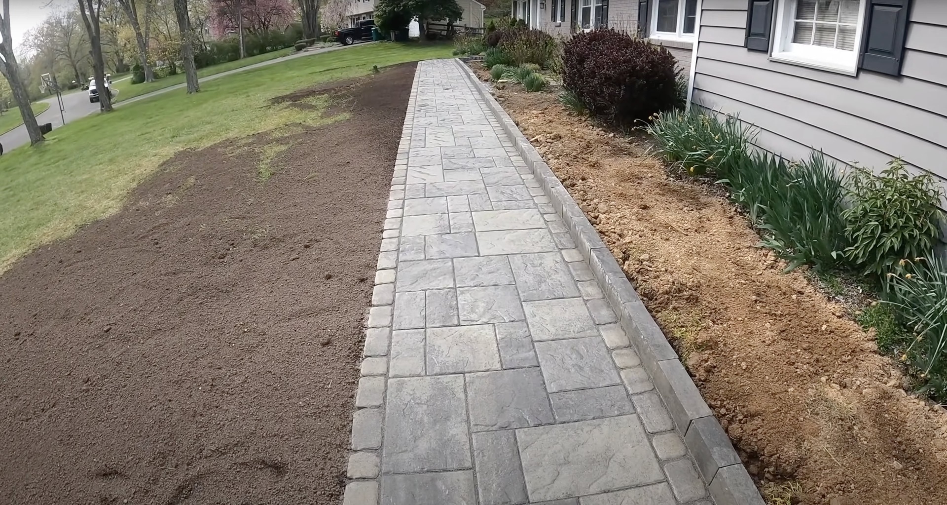 Decorative stamped concrete walkway with natural stone pattern Stamped concrete walkway with decorative stone pattern leading to residential entrance