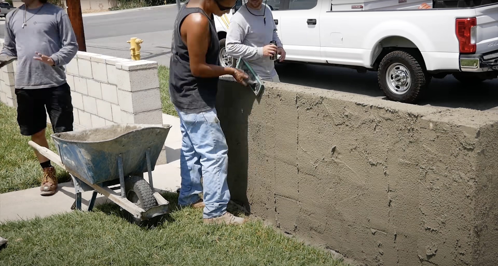 Concrete mixing and pouring process for driveway installation Professional concrete crew mixing and pouring concrete for residential driveway installation