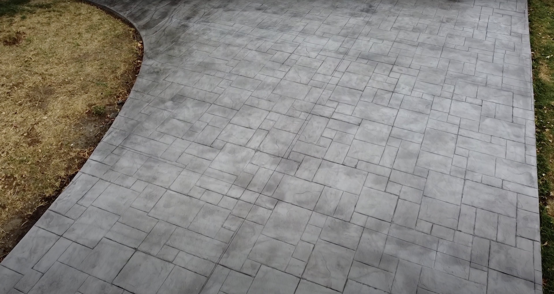 Stamped concrete with brick pattern design and professional installation Stamped concrete patio with brick-like pattern showing professional decorative concrete work