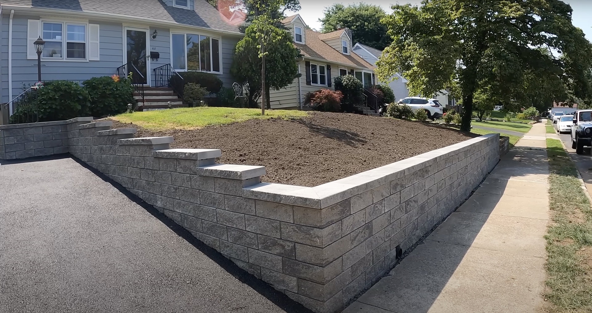 Concrete block retaining wall installation with landscape integration Professional concrete block retaining wall construction with proper drainage and landscaping